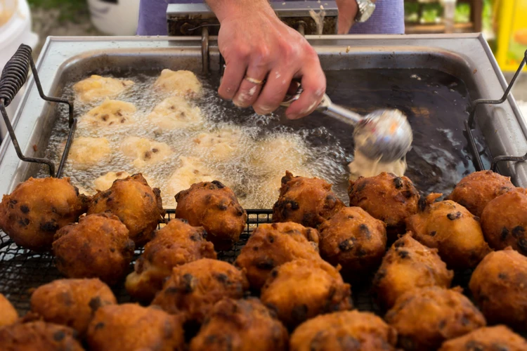 De oliebol komt snel boven drijven en dan moet je hem regelmatig omkeren. Zo kan de oliebol mooi bruin worden.