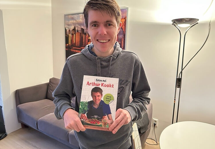 Arthur met zijn eigen kookboek. Een boek in makkelijke taal dat laat zien dat iedereen kan koken.