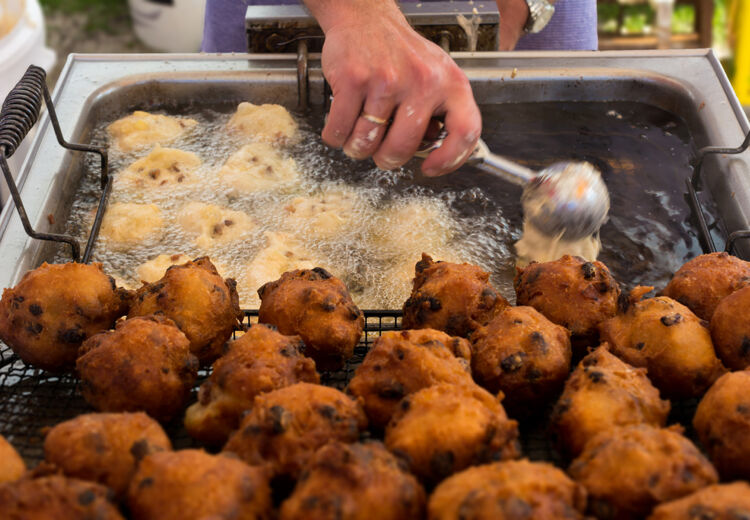 De oliebol komt snel boven drijven en dan moet je hem regelmatig omkeren. Zo kan de oliebol mooi bruin worden.