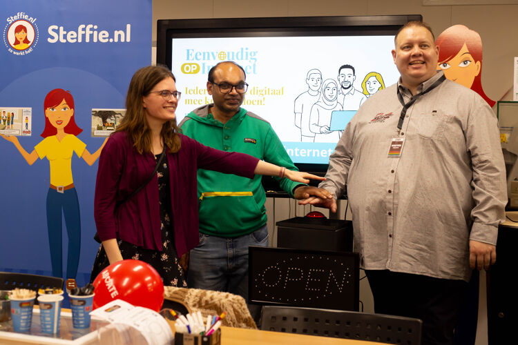 Evelien, Jaspal en Martien drukken samen op de grote rode knop om het project te starten.