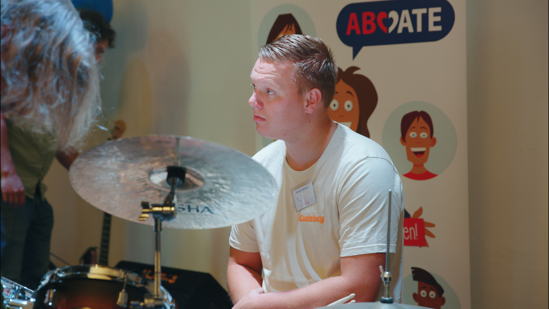 Drummer Mathijs luistert goed naar de bandcoach. Hij gaat voor het eerst drummen in een band.