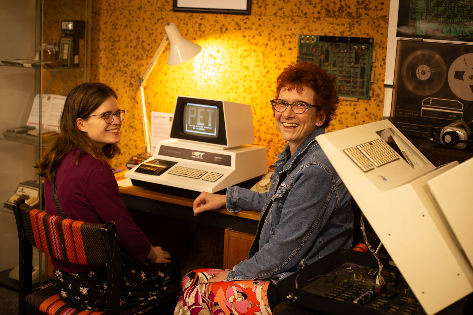 Evelien en Sabine bij een oude computer uit de jaren tachtig.